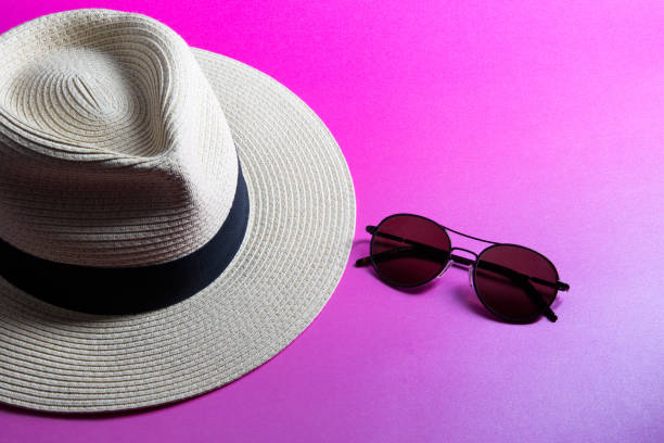 istock Straw Panama Hat and Sunglasses on a Pink Surface 1470262066