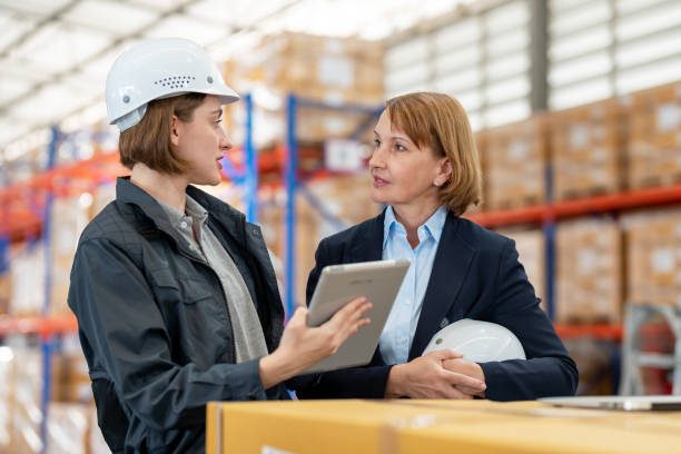 istock Teamwork engagement can increase productivity and efficiency in warehouse operations. Engineer worker holding tablet and discuss with senior Caucasian warehouse manager in the distributor warehouse factory. 1470263212