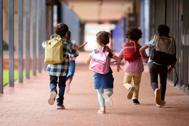 istock Group Of Multi-Cultural Elementary School Pupils Running Along Walkway Outdoors At School 1470267313