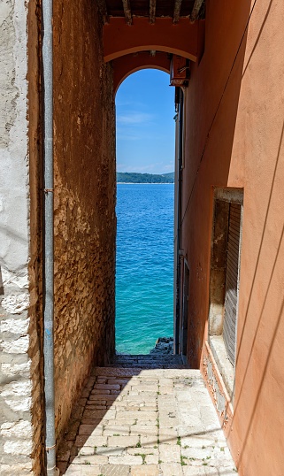 Vertical shot of a narrow alley leading to sea