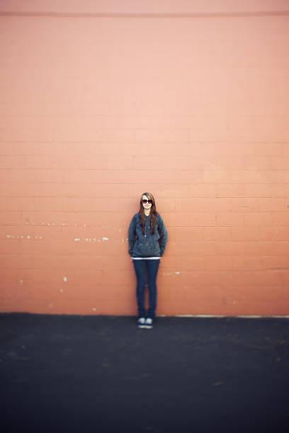 istock Woman Against Peach Brick Wall Natural Light 147026982