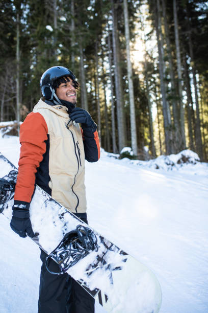 A multiracial snowboarder enjoying his winter vacation stock photo