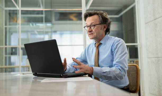 istock Businessman Talking On A Video Call Using A Laptop Computer In The Office 1470270480