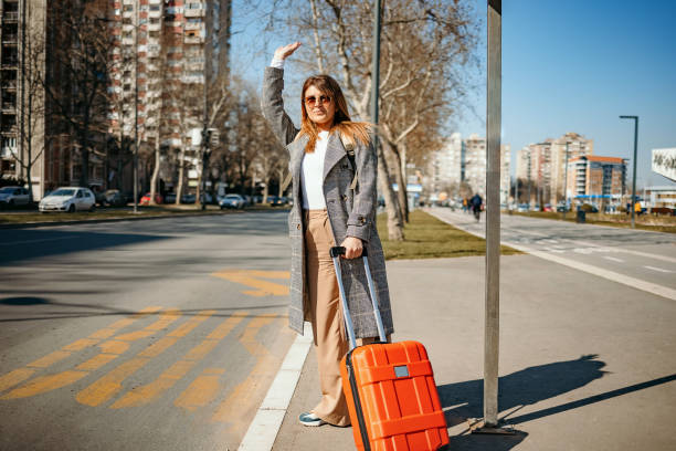 Smiling young woman tries to stop taxi