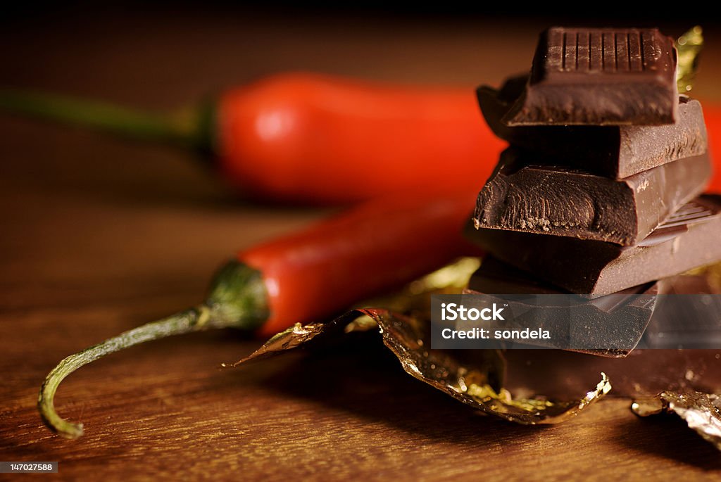chocolate and chilies chunks of dark chocolate with two red chilies Block Shape Stock Photo