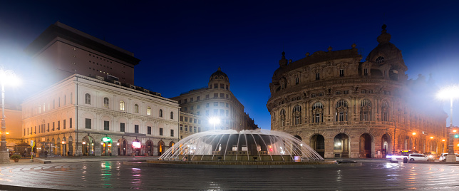 Impressive architecture and fountain of Piazza De Ferrari in night lights, Genoa, Italy