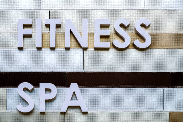 Dark grey GYM sign in capital letters on grey background with funny decorations
