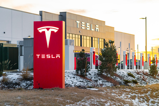 General view of a Tesla Automobile Sales and Service Center at sunset with snow visible on the ground at winter in Spokane, Washington USA.