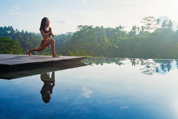 istock Yoga meditating at infinity pool on sunrise I tropical jungle 1470283013