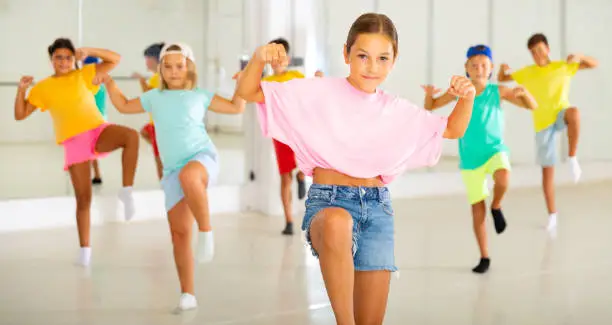 Photo of Tween girl krump dancer in choreographic studio with children