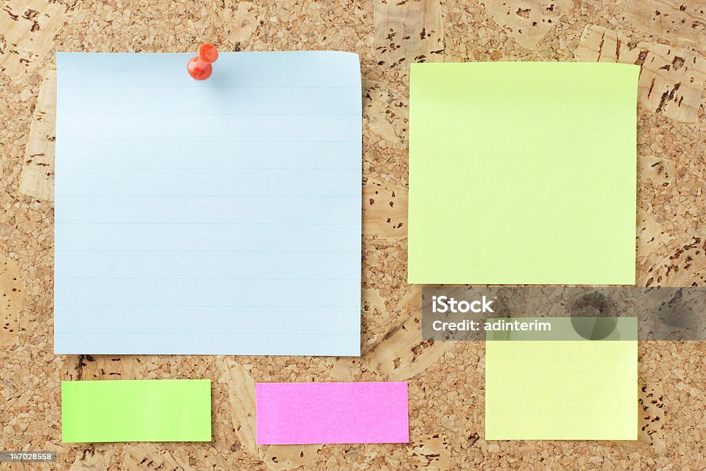 Multicolored post-it notes. Multicolored post-it notes on the cork board. (Adobe RGB). Adhesive Note Stock Photo