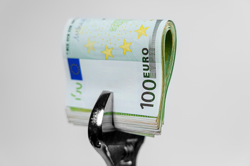 European cash euro money clamped in a wrench close up