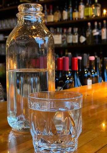 Bottle of water and glass of water in a bar