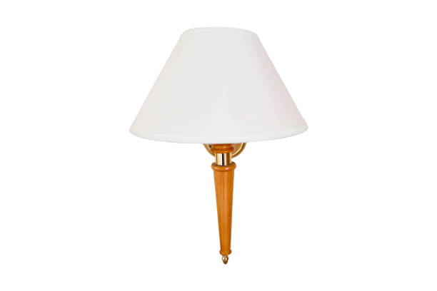 istock Wall lamp with white cone shade, copy space, isolated on a white background. Part of the interior in the hotel room. Lamp with a wooden stem attached to a beige wall. 1470309694