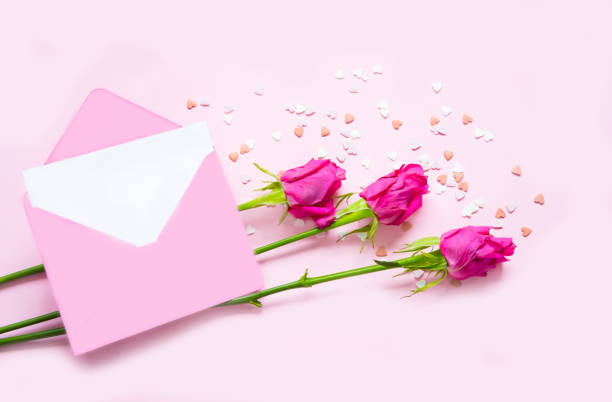 istock Pink Envelope and rose flowers on pink background. 1470313920