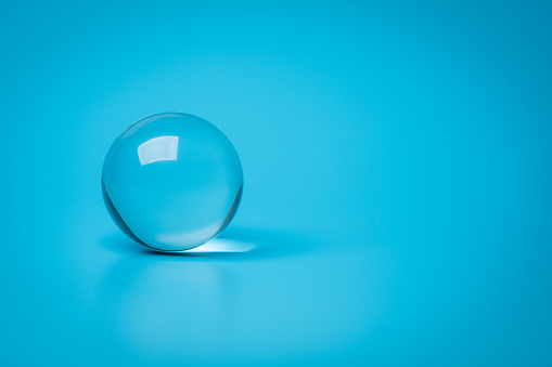 Small glass glob. Isolated on a blue background.