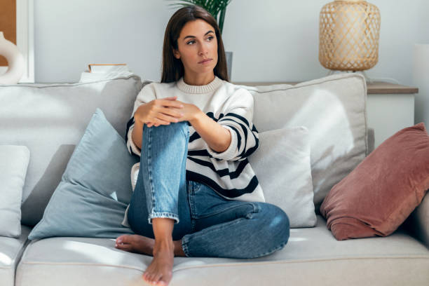 istock Depressed young woman thinking about her problems while sitting on the sofa at home. 1470316444