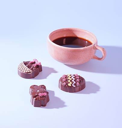 Coffee and Confections: A Pink Cup of Coffee with Festive Chocolate Bunny Rabbit and Easter Egg Candies