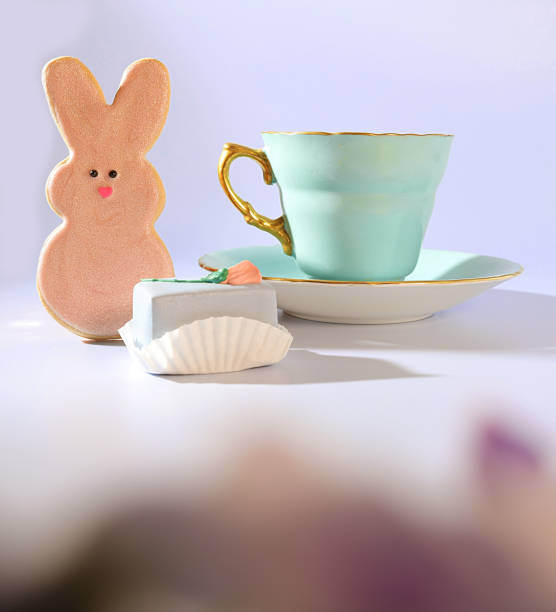 istock A Whimsical Easter Treat: A Pastel Green Teacup with a Gold Handle, a Bunny Rabbit Easter Cookie, A Pretty Pastel Cake and Meringue Candies 1470316844
