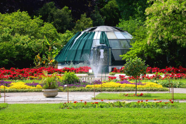Colorful flowers, lush trees and fountain in botanical garden, in Zagreb, Croatia.