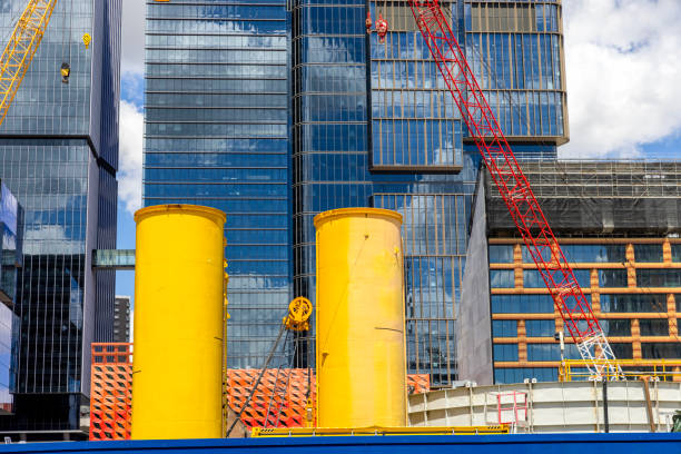 Construction site with machinery and two yellow drums, background with copy space, Parramatta NSW, full frame horizontal composition
