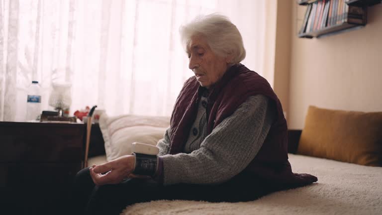 Senior woman measuring her blood pressure at home.