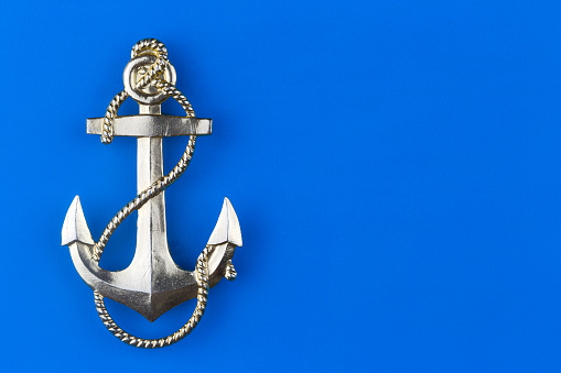 Metal anchor on a blue background