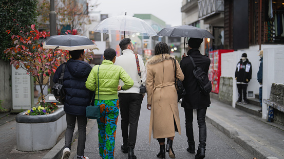 A Multi-racial group of tourist friends are walking in the streets and exploring the town in Harajuku Tokyo.
