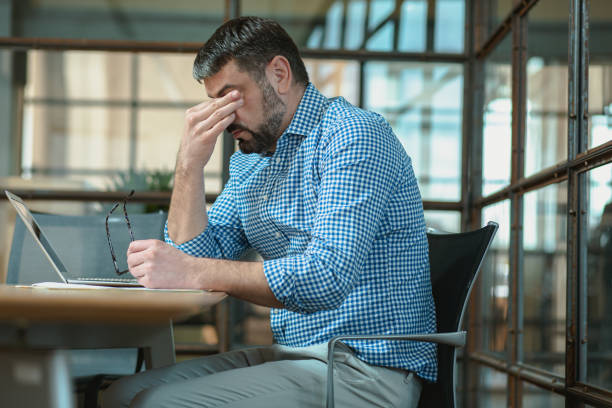 istock Tired man feeling pain, holding glasses at workplace 1470325224