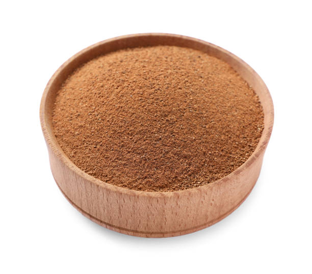 Aromatic cinnamon powder in wooden bowl on white background