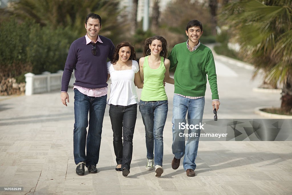 Quattro persone felice a piedi - Foto stock royalty-free di Abbigliamento