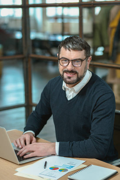 istock Smiling man in glasses typing on laptop in the office 1470325938