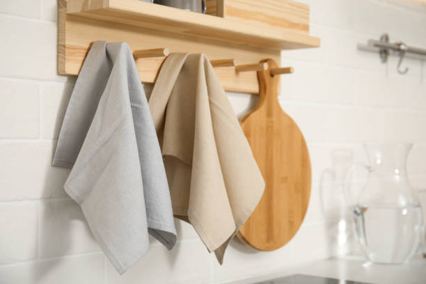 istock Different towels and wooden board hanging on rack in kitchen 1470326855
