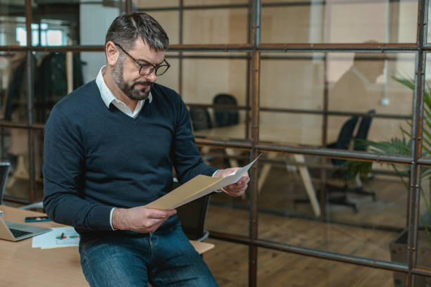 istock Employer reading documents and standing in the office 1470326956