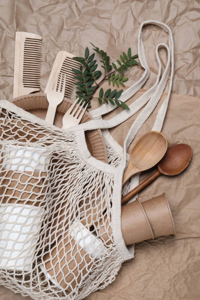 istock Net bag with different eco items on crumpled paper, top view. Recycling concept 1470326985