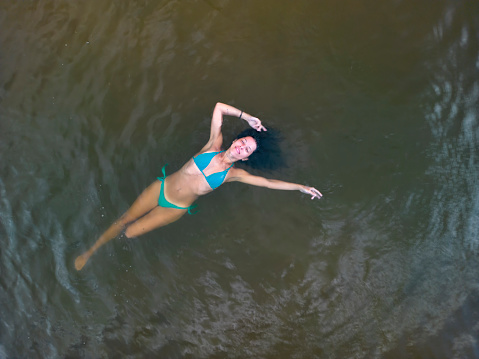 Young woman seen from above floating in the sea