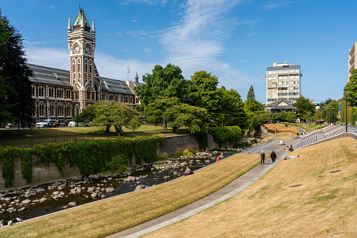Uitzicht op de klokkentoren van de universiteit van Otago, Dunedin, en de oever van de rivier Water of Leith die door de campus stroomt