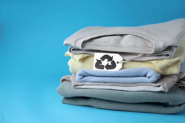 istock Clothes with recycling label on light blue background, space for text 1470329625