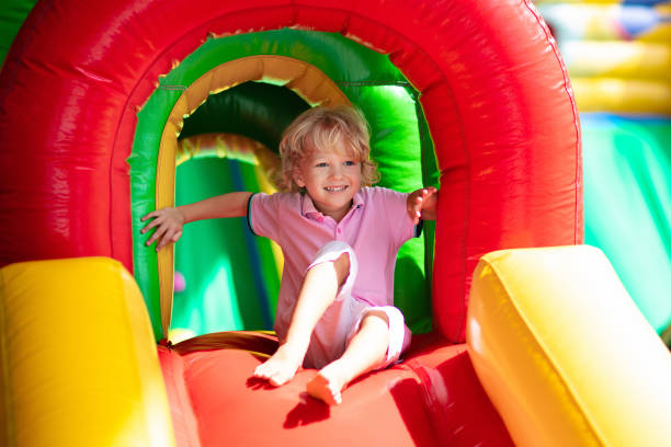 child jumping on playground trampoline. kids jump. - inflatable child playground leisure games imagens e fotografias de stock