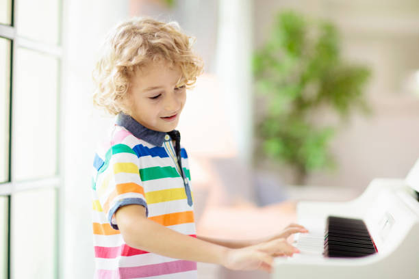 istock Child playing piano. Kids play music. 1470346193