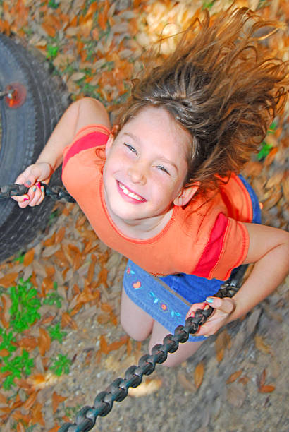 istock happy girl on swing 147034658