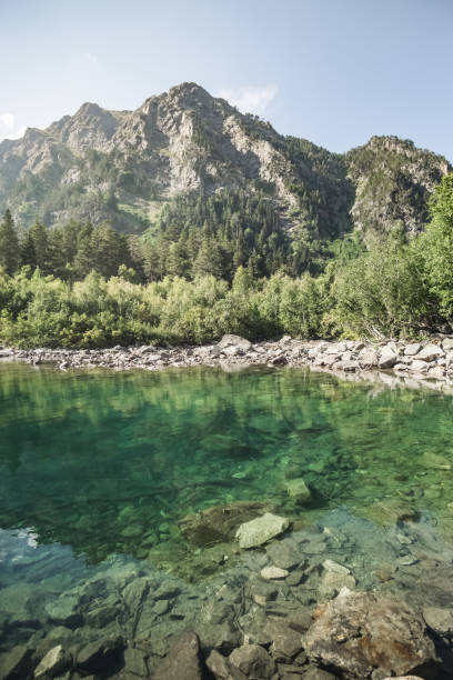 paisaje de montaña y reflexión en un lago de montaña de una montaña rocosa y bosque, una montaña lago transparente en un verano soleado en las montañas - valley georgia river mountain fotografías e imágenes de stock