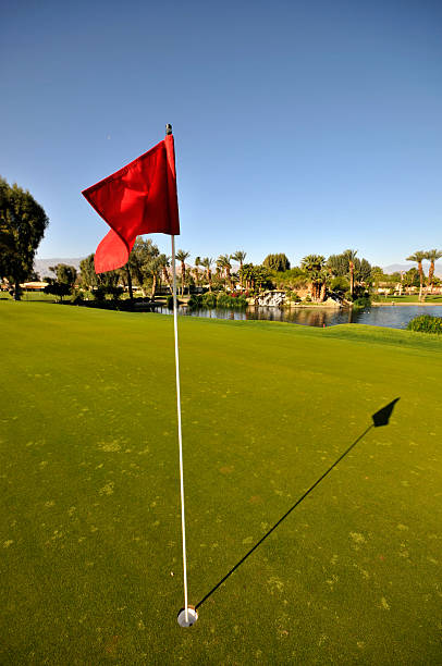 istock Golf pin with red flag and lake in the background 147034729