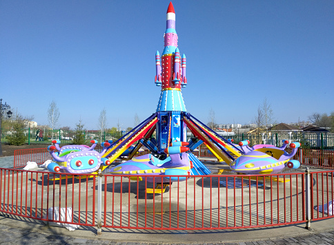 children's carousel in the form of a rocket and airplanes, seats for children. fun attraction in the children's amusement park. happy pastime on weekends, holidays or vacation