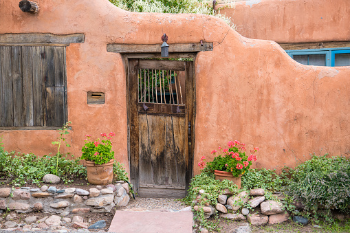 Rustic wood door set in old adobe wall in Santa Fe, New Mexico