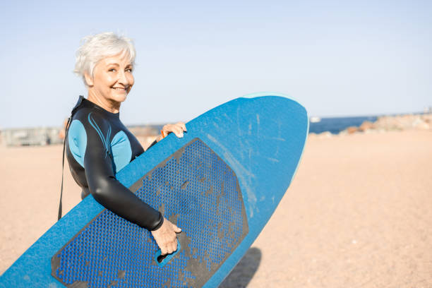istock Happy senior woman going surfing 1470355210