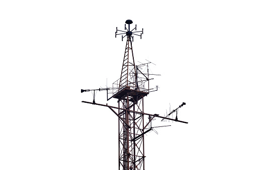 Retro antenna in the haze on the background of houses, isolated on a white background. Old grunge communication equipment construction on building background