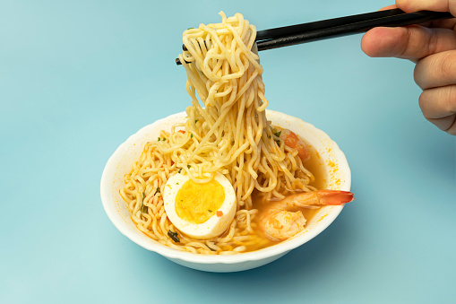 Instant Noodles on a pink background with Shrimps Asian Thai food fusion style easy dish street food popular. top view