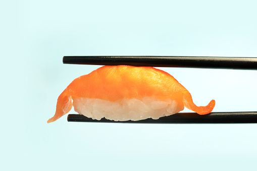 Savor the Flavor of Japan: Hosomaki Sushi Between Chopsticks, Set Against the Iconic Japanese Flag