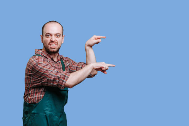 istock nervous bearded young workman, male point with hand, looking at camera, 1470356427